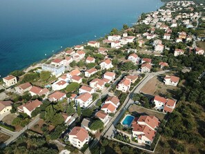 An aerial view of a coastal residential area with houses, roads, and a clear blue sea. - Vacation home  by Interhome (Petrčane)