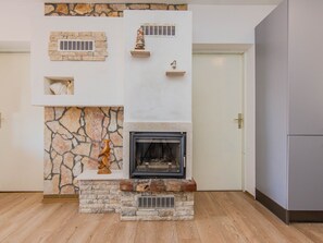 Una chimenea con detalles de piedra y un televisor integrado.