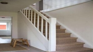 A staircase with white railings and beige steps. - Ferienhaus in Püttsee auf Fehmarn (Püttsee)