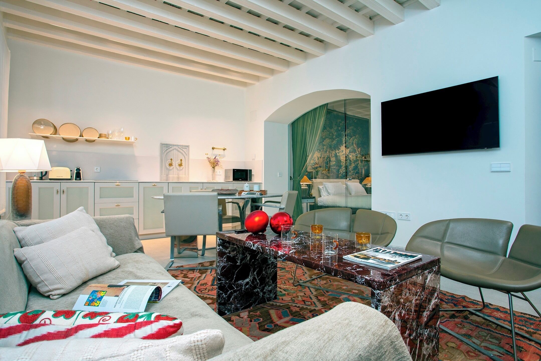 Ein modernes Wohnzimmer mit einer Couch, einem Couchtisch und einem an der Wand montierten Flachbildfernseher.