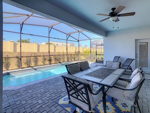 A covered outdoor area with a pool, seating, and a ceiling fan. - ☆☆☆☆☆ Cozy Windsor Westside Home • Private Pool • Themed Rooms • Disney ☆☆☆☆☆ (Kissimmee)