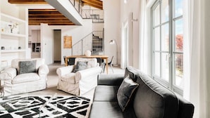 A spacious living area with a staircase, a dining table, and a large window. - w* | Luxury 5BR Retreat near Navigli (Milano)