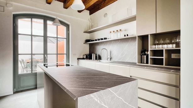 A modern kitchen with a marble countertop, built-in cabinets, and a large window. - w* | Luxury 5BR Retreat near Navigli (Milano)