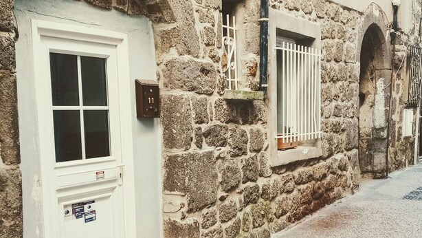 A narrow cobblestone street with a white door and window, stone walls, and a blue tiled path. - Historic district of Agde (Agde)
