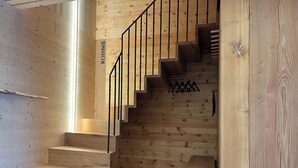Una escalera de madera con barandilla de metal y una placa con el nombre 'ROBINIE'.