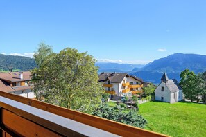 Ein Wohngebiet mit Häusern, einer Kirche und Bergen im Hintergrund.