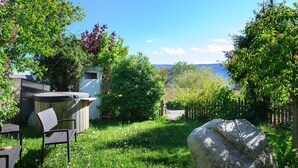En trädgård med en bubbelpool, utemöbler och en stor sten.
