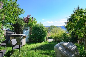 Ein Garten mit Whirlpool, Gartenmöbeln und einem großen Felsen.