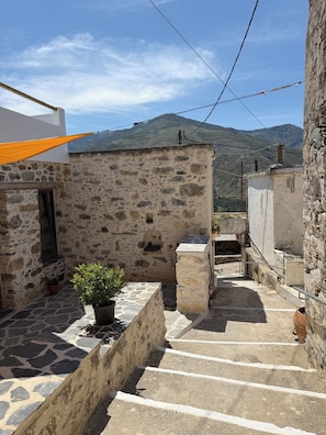 A narrow stone staircase leading to a building with a stone wall and a potted plant. - ELAFONISI PETRA HOUSE - Traditional Stone House near Elafonisi Beach 2BD, 2BTH (Kissamos, Chania)