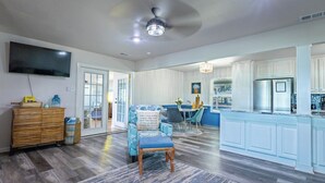 A modern kitchen with a built-in refrigerator, a dining area with a table and chairs, and a living room with a sofa and a television. - Never a Bad Day at PK Lake- Waterfront, Pool Table, Firepit (Graford)