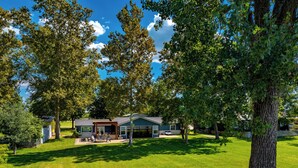 A modern house with a patio, a garage, and a well-maintained lawn. - Never a Bad Day at PK Lake- Waterfront, Pool Table, Firepit (Graford)