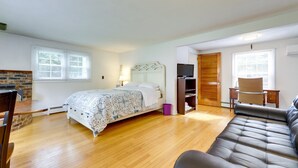 Une chambre à coucher avec un lit, une télévision, un bureau et un canapé en cuir.