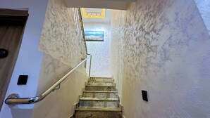 A marble staircase with a handrail leading to a landing. - Bayford Suites (Abuja)