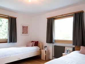 A bedroom with two single beds, a radiator, a bedside table with a lamp, and a framed picture on the wall. - Schaivel, (Müstair) by Interhome (Müstair)