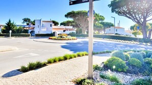Un panneau indicateur avec plusieurs flèches pointant vers « Academia de Tênis », « Centro Center » et « Vale do Golfe ».