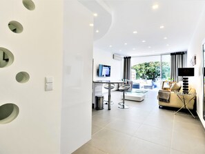Ein modernes Wohnzimmer mit einer Couch, einem Couchtisch und einem Fernseher.