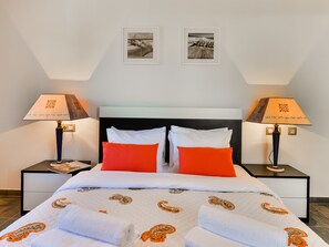 A hotel room with a bed, two nightstands, two lamps, and two framed pictures on the wall. - Falesia Beach A by Interhome (Albufeira)