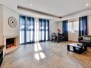 A spacious living room with a fireplace, a dining area, and a sofa. - Apartment  by Interhome (Albufeira)