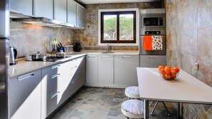 A modern kitchen with stainless steel appliances, a window with a view, and a white countertop. - Apartment  by Interhome (Albufeira)