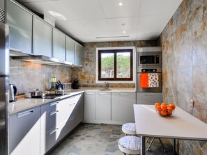 A modern kitchen with stainless steel appliances, a window with a view, and a white countertop. - Apartment  by Interhome (Albufeira)