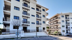 A multi-story residential building with balconies, a gated entrance, and a parking area. - Apartment  by Interhome (Albufeira)