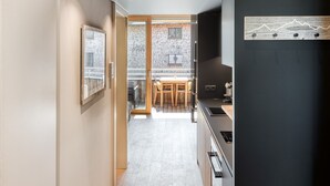 A modern interior with a kitchen, dining area, and a view through a glass door. - Studio La Montanara in Brand (Brand)