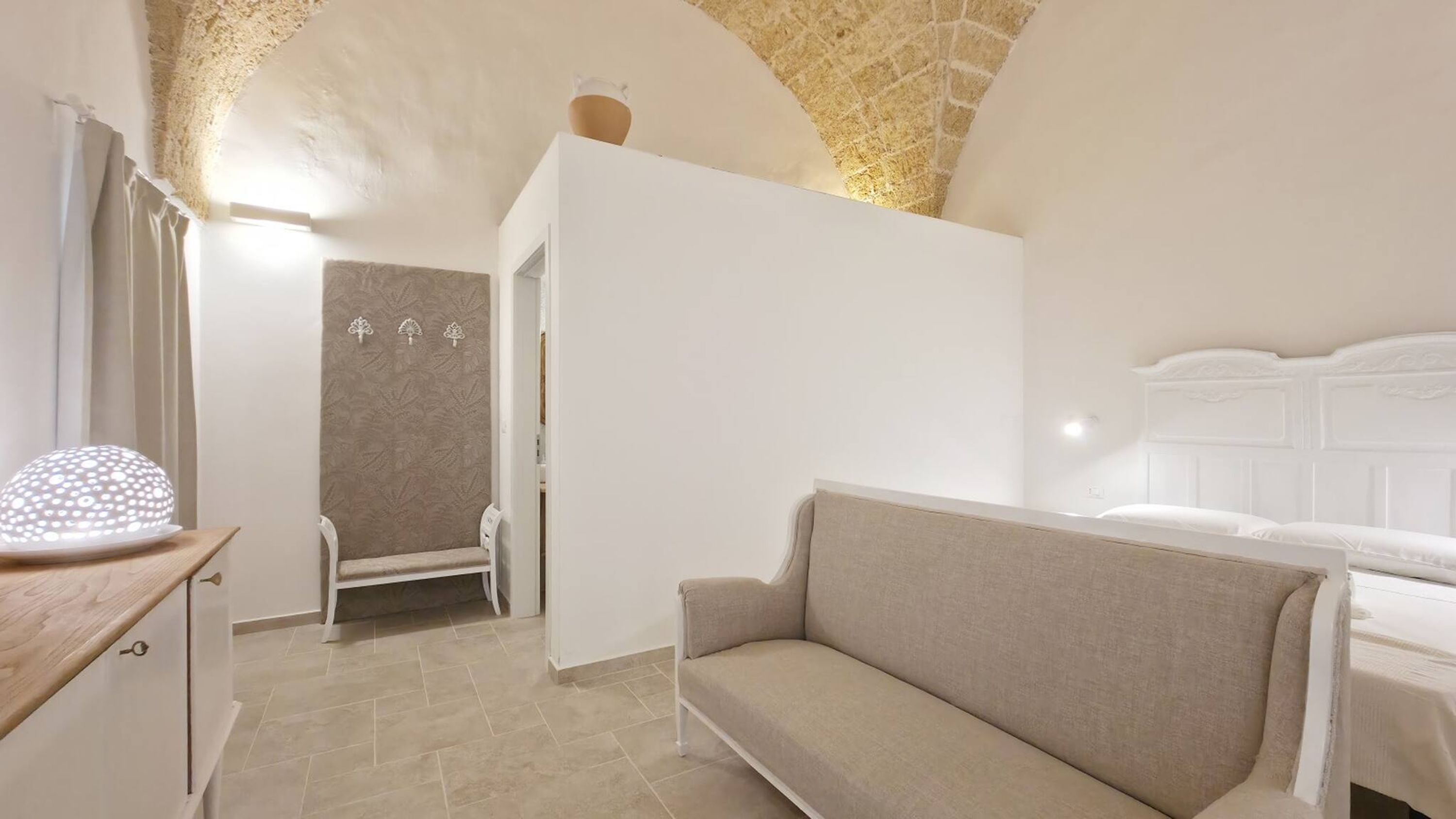 Une chambre à coucher avec un lit, un canapé, une chaise et une petite table.