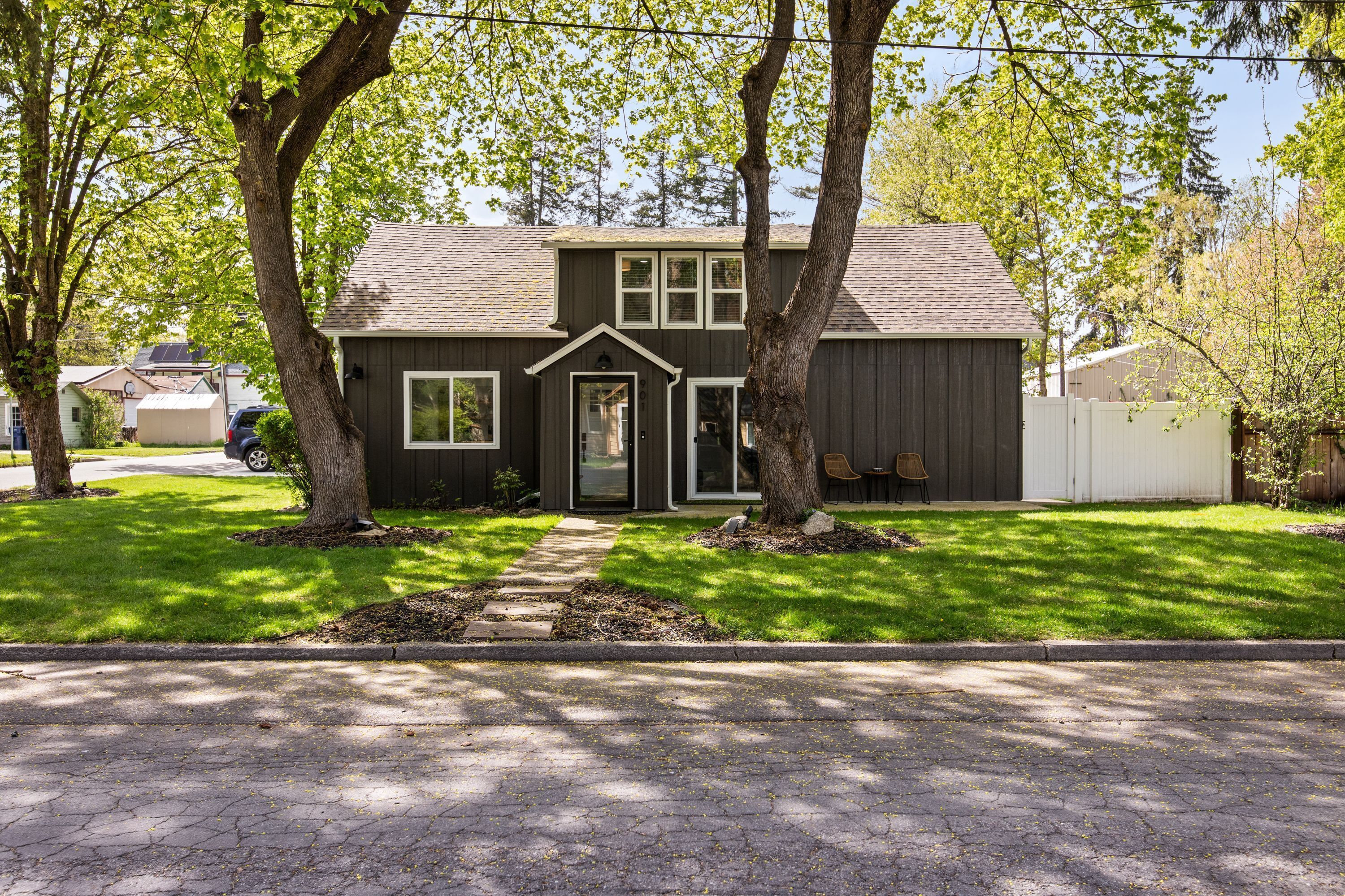 A two-story house with a front porch, a driveway, and a well-maintained lawn.