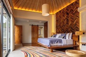 Un dormitorio moderno con una cama grande, techo de madera y pared con motivo de espiga.