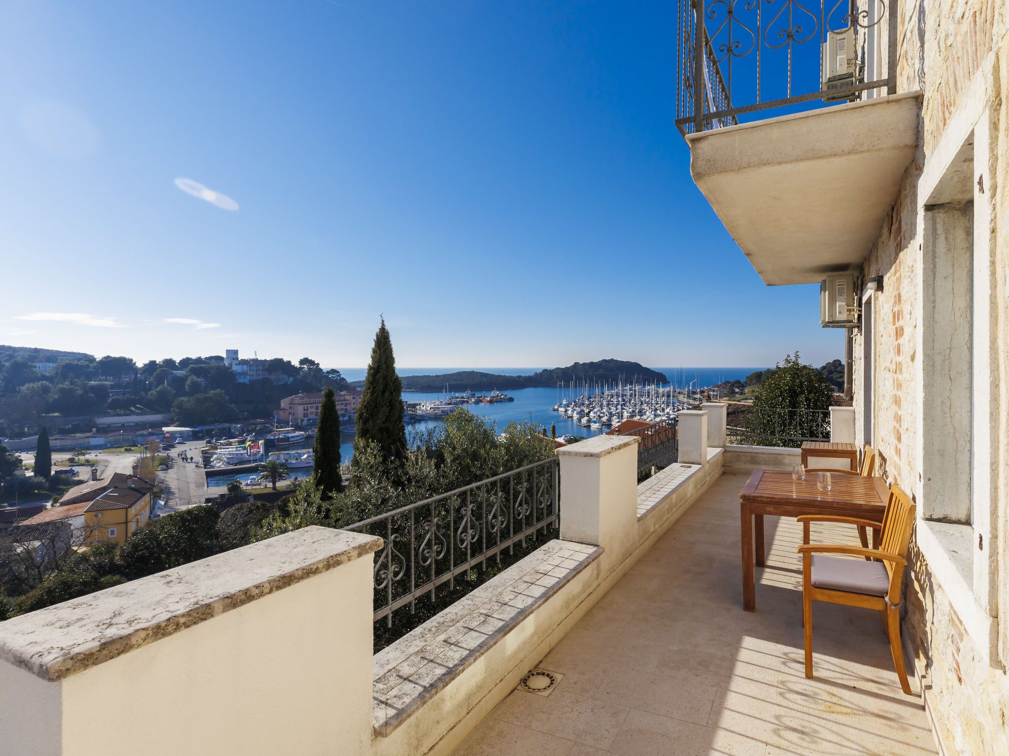 A balcony with a view of a marina and cityscape.