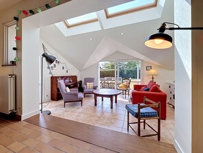 Ein geräumiges Loft mit hohen Decken, einem Klavier, einem roten Sofa und einem Essbereich.