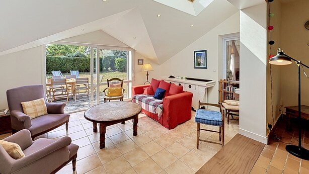 A spacious loft with a high ceiling, skylights, a dining area, and a kitchen.