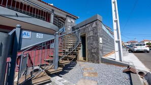 A building with a stone facade, a metal staircase, and a sign indicating a local lodging. - Kaya Canhas by LovelyStay (Poiso)