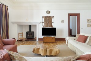 A living room with a fireplace, a television, a sofa, and a coffee table.
