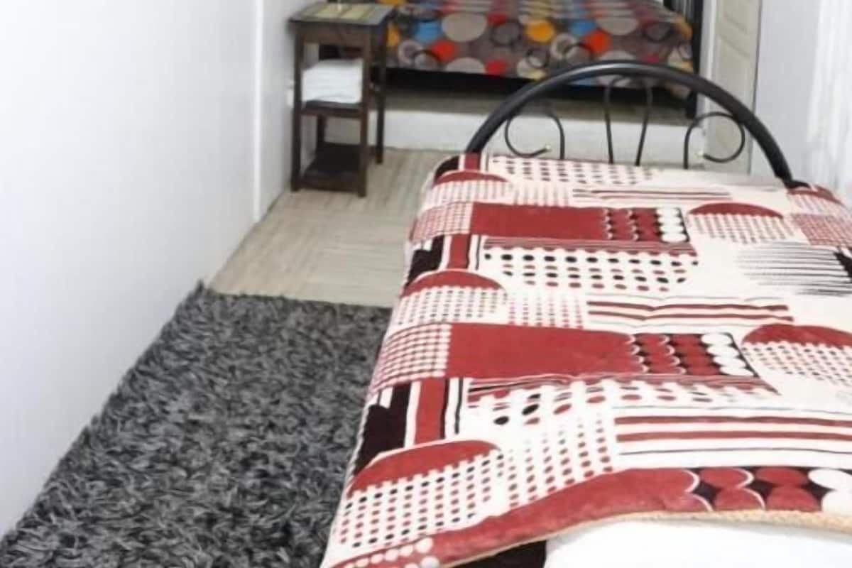 Una camera da letto con un letto, una sedia, una scrivania e una finestra.