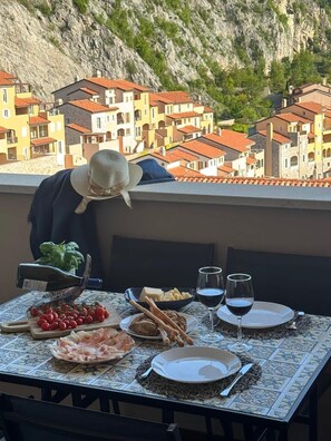 Un tavolo apparecchiato con cibo e vino, con vista su un villaggio montano.