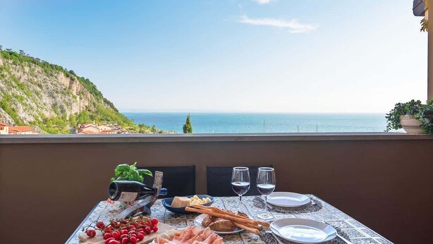 Mesa dispuesta con comida y bebidas, con vista al mar.