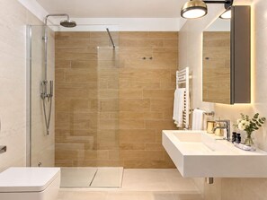A modern bathroom with a glass shower enclosure, a white sink, and a large mirror. - Levante - Portopiccolo Apartments (Sistiana)