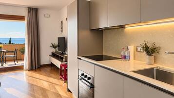 Eine moderne Küche mit Backofen, Spüle und Essbereich inklusive Tisch und Stühlen.