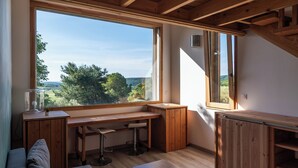 A room with a large window, wooden desk, and a built-in cabinet. - Family property in a green setting - 9 to 10 people (Nébian)