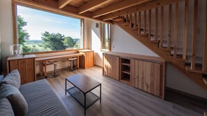 A modern interior with a wooden staircase, a dining area, and a sofa. - Family property in a green setting - 9 to 10 people (Nébian)