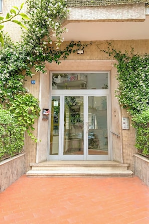 A building entrance with a glass door, a number '73' sign, and a small mailbox. - Naples, Apartment up to 4 people, very close to Metro and Funiculars (Napoli)
