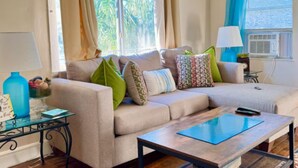 Ein Wohnzimmer mit einer Couch, einem Couchtisch, einem Glastisch und einer Lampe.
