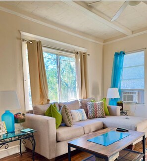 A living room with a sofa, a coffee table, a glass table, and a lamp. - 2/1  St Pete 🏠-3 mi to Beach 1 mile to Downtown. New listing discounts (St. Petersburg)