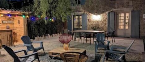 An outdoor patio area with seating, a table, and string lights.