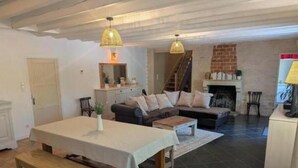 Una sala de estar con sofá, mesa de comedor y chimenea.