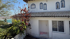 Un edificio tradicional con tejado de tejas, pared de piedra y un pequeño jardín.