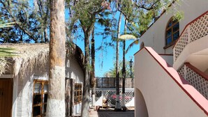 A courtyard with white buildings, a wooden door, and a staircase.
