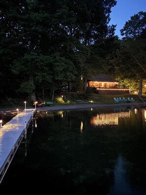 A lakeside cabin with a dock extending into the water, surrounded by trees. - Relaxing 3 bedroom LAKE retreat, with huge deck, kayaks, AC and wifi. (Niles)
