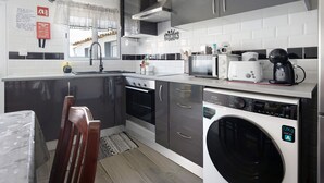 A compact kitchen with a washing machine, a toaster, and a coffee maker. - Holiday Home 'Casa Do Pacheco' with Sea View, Wi-Fi and Air Conditioning (Salga)